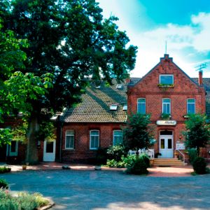 Hotel Allerhof Hausansicht mit großem Vorplatz und Sitzbereich sowie Parkplätzen an der Seite